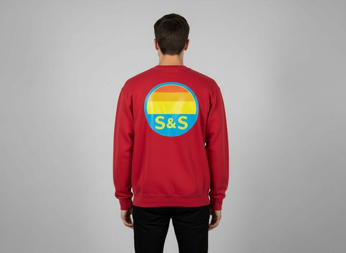 Person wearing a crimson red sweatshirt with a colorful logo on the back against a gray background